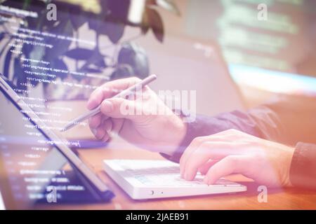 Businessman working with laptop computer on wooden desk in modern office . Programmers and cyber security technologies design. Stock Photo