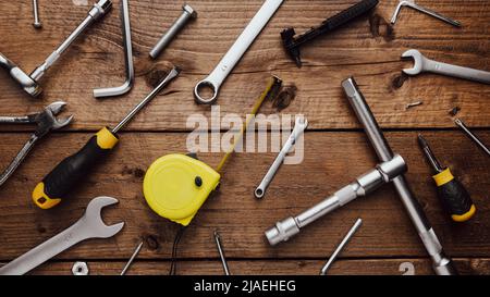 Flat lay with DYI composition of various work, carpentry tools knolled on brown wooden decks background pattern working table. Top view on new hand tool set for repair and construction kit, overhead