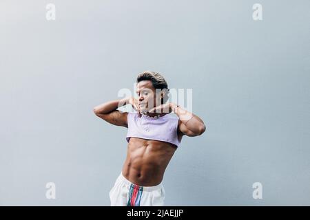 Young handsome man posing against grey wall in stylish clothes Stock Photo