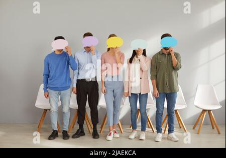 Group of people hiding their faces behind speech bubbles and sharing opinions anonymously Stock Photo