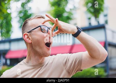 Happy african casual man in glasses sits at cafe table looking at camera, cheerful black student posing studying with book in coffee house, smiling bu Stock Photo