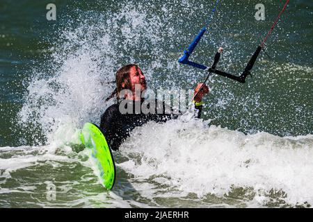Male kitesurfer gets hit by a wave after fall, closeup Stock Photo