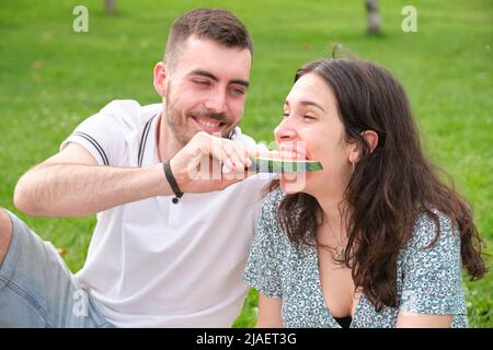 Happy young man giving watermelon to his girlfriend. Stock Photo