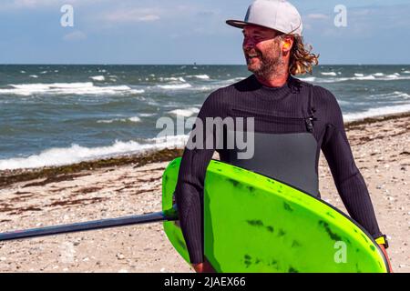 Portrait of a male kite foil surfer with a board on the beach Stock Photo