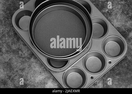 Baking trays and cake tins on a black stone background. Cooking utensils concept Stock Photo