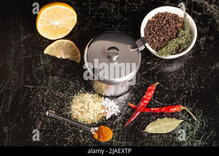 Metal container for spices with assortment of spices for cooking on a black background,top view Stock Photo