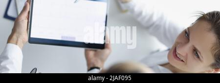Top view of practitioners discussing patients cardiogram and treatment Stock Photo