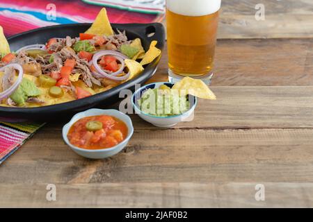 Tray with nachos, sauces and beer. Stock Photo