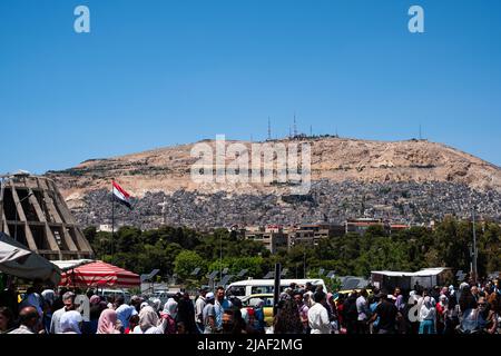 Damascus, Syria - may 2022: Street traffic and mountain (Mount Qasioun) background in city of Damascus, Syria