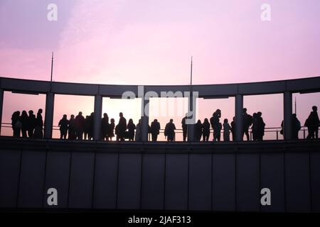 People on the observation deck of Umeda Sky Building, Osaka, Japan. Silhouettes on sunset sky background Stock Photo