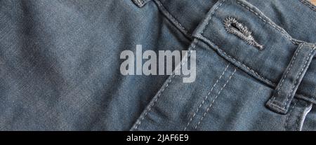 Close up detail of pocket and button front view of light blue jeans denim Stock Photo