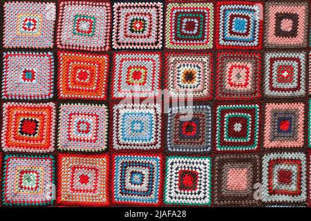 Detail of a crocheted patchwork multicolor wool blanket. Stock Photo