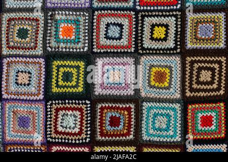 Detail of a crocheted patchwork multicolor wool blanket. Stock Photo