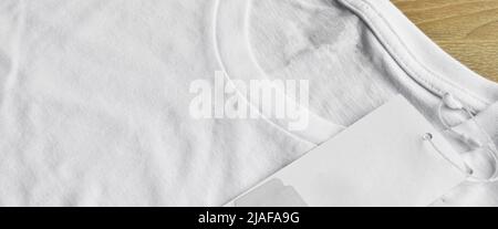 White clean blue t-shirt and blank empty label, on wooden floor Stock Photo