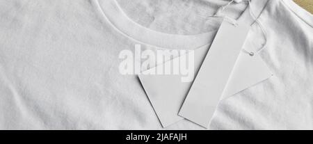 White clean blue t-shirt and blank empty label, on wooden floor Stock Photo