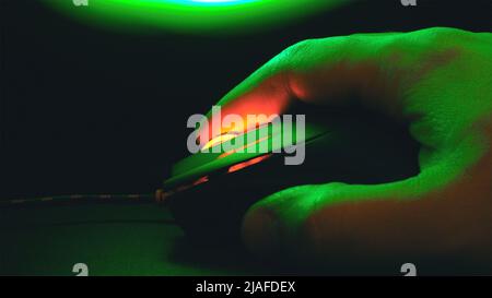 Palm on a computer mouse glowing in the dark Stock Photo