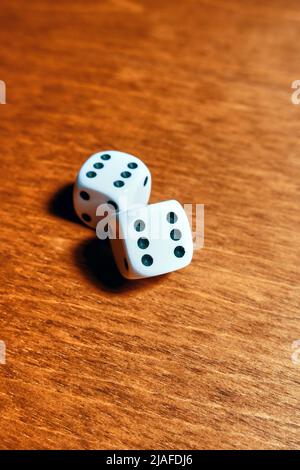 Close-up of two dice with rolled sixes on a wooden table Stock Photo
