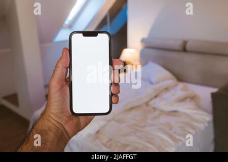 Smartphone mockup screen, man using mobile phone in bedroom, selective focus Stock Photo