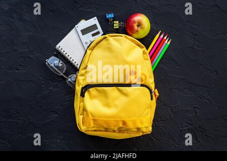 Yellow school backpack with student accessories. College and school concept Stock Photo