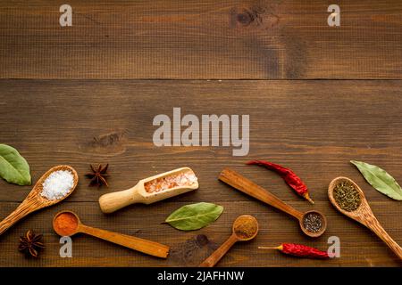 Layout of spices and herbs in wooden spoons, top view Stock Photo
