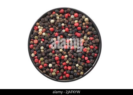 Bowl of dried aromatic peppercorns, isolated on white. Colourful pepper mix - black, red, green and white peppercorns. Top view. Stock Photo