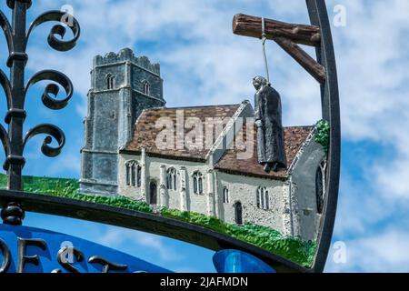 Brandeston village sign against foliage and lightly clouded blue sky Stock Photo