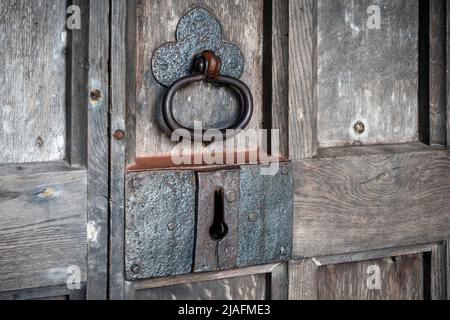 Detail of heavy duty church door handle on paneled old wooden heavy grained door Stock Photo