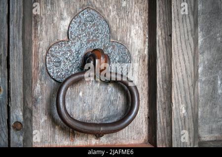 Detail of heavy duty church door handle on paneled old wooden heavy grained door Stock Photo