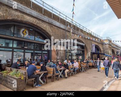 General view of tables outside the Battersea Brewery on Arches Lane (under the Grosvenor Railway Bridge), Battersea, Wandsworth, South London, UK. Stock Photo