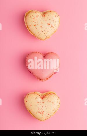 Heart shaped Sweet macarons on a pink background. Top view. Stock Photo