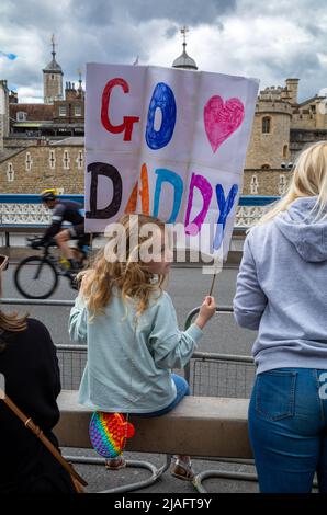 A young girl holds a sign saying 'Go Daddy' as she waits for her father to cross the finish line on Tower Bridge in London, at  RideLondon 2022. The e Stock Photo