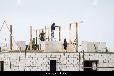 Minsk, Belarus - December 01, 2018: Builders are working on the construction of the roof of a residential building Stock Photo