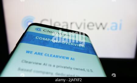 Mobile phone with website of US facial recognition company Clearview AI Inc. on screen in front of logo. Focus on top-left of phone display. Stock Photo