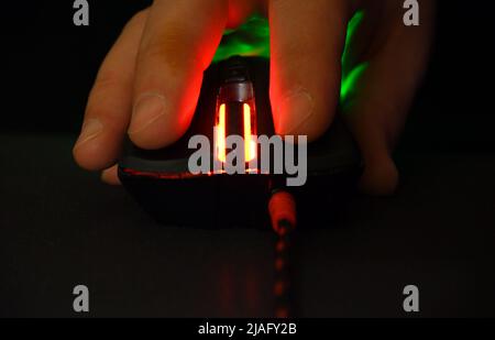 Computer mouse and hand glows in the dark Stock Photo