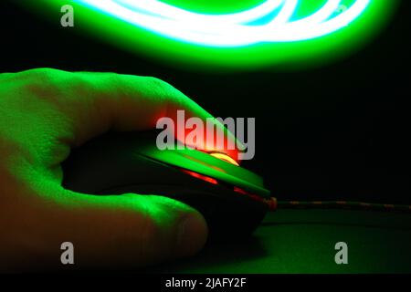 Computer mouse and hand glows in the dark Stock Photo
