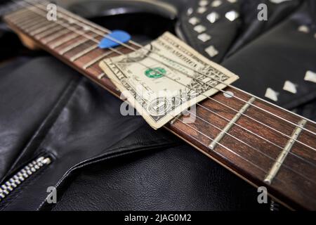 One dollar bill guitar neck plectrum and leather jacket Stock