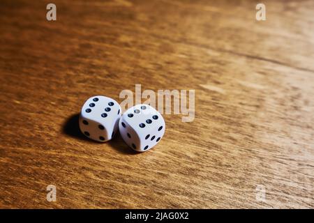 Two sixes on the dice. White dice on wooden surface Stock Photo