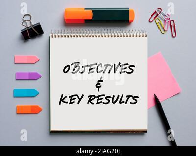The message objectives and key results okr written on a notebook on business office desktop. Stock Photo