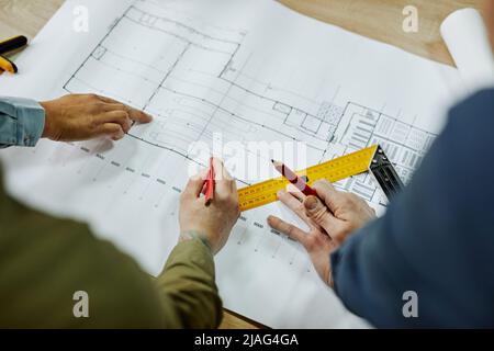 Top view close up of two architects discussing floor and furniture plans, copy space Stock Photo