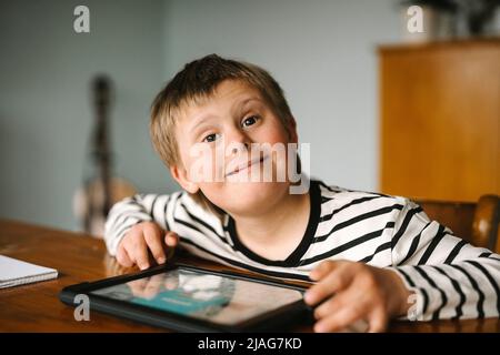 Portrait of happy boy with down syndrome sitting at table Stock Photo