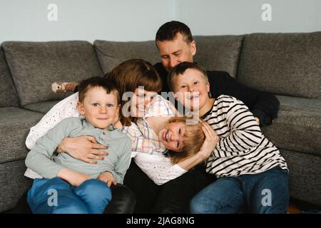 Portrait of happy children with parents against sofa in living room Stock Photo