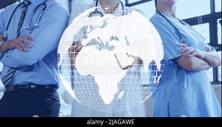 Image of spinning globe model over diverse medical staff. world health day concept digitally generated image. Stock Photo