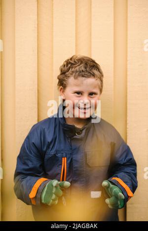 Portrait of happy boy with down syndrome gesturing against wall Stock Photo