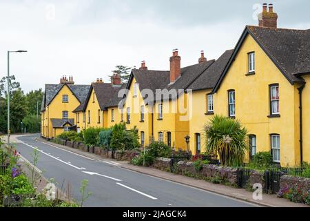 Distinctively painted cottages lining a village roadside in East Devon, UK Stock Photo