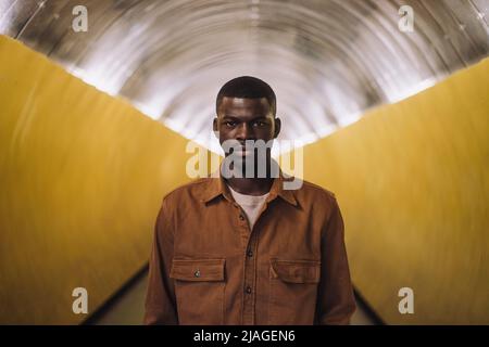 Portrait of serious young man standing in tunnel Stock Photo