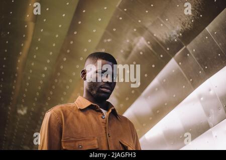 Low angle view of young man standing in subway tunnel Stock Photo