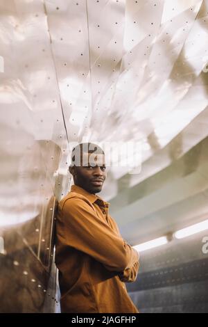 Portrait of smiling young man standing with arms crossed in tunnel Stock Photo
