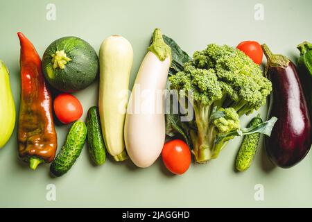 Eco friendly organic green vegetables on green background. Flat lay, top view. Healthy clean eating diet and detox Stock Photo