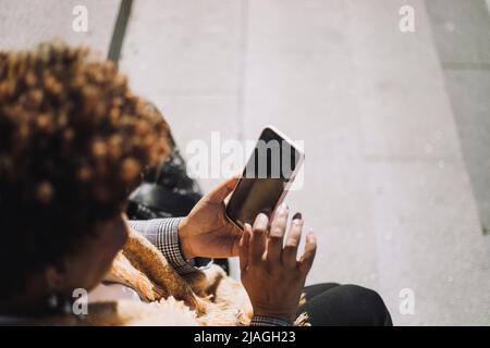 Senior woman using smart phone during sunny day Stock Photo