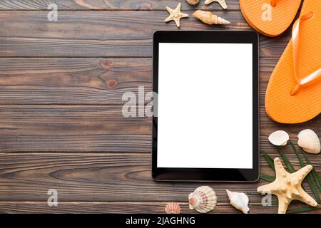 Flat lay composition with tablet and beach accessories on colored background. Tablet computer with blank screen mock up with copy space. Stock Photo